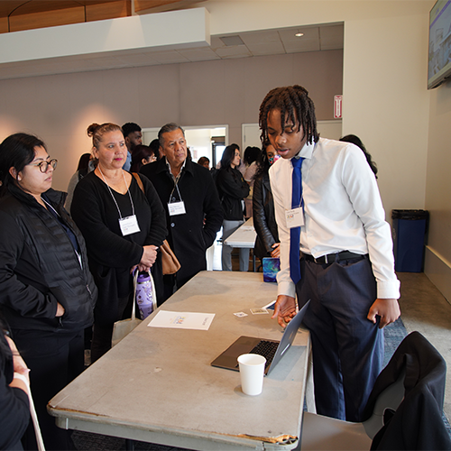 Youth participant Caleel Smith (right) presents his poster session to attendees at the 2025 Los Angeles Crossroads Policy Forum Event held at LA Trade Tech College