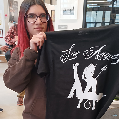 Boyle Heights YouthSource intern Gizelle Lopez showing off her Luv Angelez business logo on a freshly silk-screened t-shirt